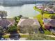 Aerial view of a house in a lakeside community with a screened-in lanai and lush landscaping at 256 New River Dr, Poinciana, FL 34759