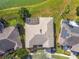 Aerial view of the house with a screened-in patio, surrounded by a well-manicured lawn and a serene lake at 256 New River Dr, Poinciana, FL 34759