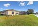 Lush backyard with a beautiful lake view and a screened-in patio on a sunny day at 256 New River Dr, Poinciana, FL 34759