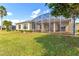 Spacious backyard with screened patio, lush lawn, and mature trees at 256 New River Dr, Poinciana, FL 34759