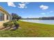 Expansive lake view from the backyard with well-manicured landscaping and a screened lanai at 256 New River Dr, Poinciana, FL 34759