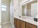 Bright bathroom featuring a vanity with a sink, neutral walls, and a large mirror at 256 New River Dr, Poinciana, FL 34759