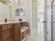 Bathroom with a vanity, pull-out drawers and an open doorway leading to a tiled hallway at 256 New River Dr, Poinciana, FL 34759