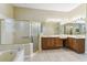 Bright bathroom with a large vanity, soaking tub, and a separate glass enclosed shower at 256 New River Dr, Poinciana, FL 34759