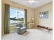 Bright bedroom with a serene lake view, comfortable seating, and a ceiling fan at 256 New River Dr, Poinciana, FL 34759