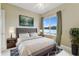 Inviting bedroom with large window overlooking the lake; neutral colors and nice furnishings at 256 New River Dr, Poinciana, FL 34759