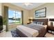 Serene bedroom with lake view, plush bedding, stylish decor, and a ceiling fan at 256 New River Dr, Poinciana, FL 34759