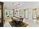 Dining area features a decorative chandelier and large windows offering an inviting atmosphere at 256 New River Dr, Poinciana, FL 34759