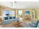 A lovely living room features a ceiling fan, large windows, tile floors, and comfortable furniture at 256 New River Dr, Poinciana, FL 34759