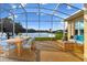 Relaxing screened patio features comfortable seating and dining, with peaceful lake views at 256 New River Dr, Poinciana, FL 34759