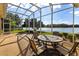 Enclosed patio with beautiful water view, outdoor seating, and a round table for dining at 256 New River Dr, Poinciana, FL 34759
