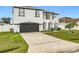 Two-story house with white exterior, black accents, and a two-car garage at 269 Beckenham Dr, Kissimmee, FL 34758