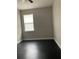 Simple bedroom with dark laminate flooring, neutral walls, and a window with blinds at 1645 Cumin Dr, Kissimmee, FL 34759