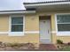 House exterior featuring a light yellow painted stucco, a white door, and a brick walkway at 1645 Cumin Dr, Kissimmee, FL 34759
