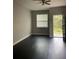 Living room featuring dark laminate flooring, neutral walls, and access to a patio at 1645 Cumin Dr, Kissimmee, FL 34759
