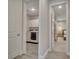 Hallway view of laundry room with washer and dryer and bedroom with carpet at 19041 Blueleaf St, Orlando, FL 32827