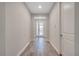 Light-filled hallway with wood-look tile flooring leads to the front door and other parts of the home at 19041 Blueleaf St, Orlando, FL 32827