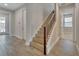 Hallway featuring wood-look tile flooring, stairs with wooden treads, and access to multiple rooms at 19041 Blueleaf St, Orlando, FL 32827