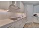 Modern kitchen boasts white cabinetry, stainless steel range hood, and sleek countertops for a contemporary look at 19041 Blueleaf St, Orlando, FL 32827