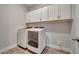 Laundry room with modern white washer and dryer and storage cabinets at 19041 Blueleaf St, Orlando, FL 32827