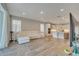 Spacious living room open to the kitchen, featuring wood-look tile floors and abundant natural light at 19041 Blueleaf St, Orlando, FL 32827