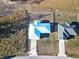 Aerial view of two-house property with light blue and gray roofs, fenced yards, and driveways at 25 Juniper Loop Cir, Ocala, FL 34480