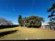 Large backyard with grass, trees, and a wooden fence at 2704 Kendall Ave, Kissimmee, FL 34744