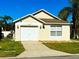 House exterior featuring a single-story home with a garage and well-maintained lawn at 2981 Kokomo Loop, Haines City, FL 33844