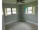 Neutral bedroom with gray tile flooring, two windows, and a ceiling fan at 436 Michigan Ave, St Cloud, FL 34769