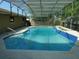 A refreshing pool with a screened enclosure surrounded by lush greenery in the backyard at 436 Michigan Ave, St Cloud, FL 34769