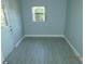 View of an empty room with gray flooring, light blue walls, and a window with tree views at 436 Michigan Ave, St Cloud, FL 34769
