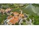 Aerial view of a Mediterranean-style community with terracotta roofs surrounding a serene lake at 521 Milano Rd, Kissimmee, FL 34759
