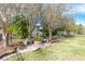 Serene backyard featuring a charming stone patio with benches and lush landscaping overlooking the water at 521 Milano Rd, Kissimmee, FL 34759