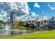 Picturesque Mediterranean-style community by a pond with fountain and lush green lawns under a blue sky at 521 Milano Rd, Kissimmee, FL 34759
