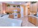Open-concept kitchen with light wood cabinets, ample countertop space, white appliances, and decorative plants at 521 Milano Rd, Kissimmee, FL 34759