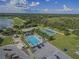 Aerial view showcasing community amenities: pool, tennis courts, parking, and golf course at 1280 Osprey Landing Dr, Lakeland, FL 33813