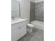 Modern bathroom with white vanity, grey tile, and bathtub at 1810 Dunbar St, Bartow, FL 33830