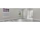 Spacious bedroom with grey flooring, featuring a large window and door to a bathroom at 1812 Corolla Ct, Deltona, FL 32738