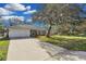 Newly renovated single-story home with a large tree and driveway at 1812 Corolla Ct, Deltona, FL 32738