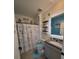 Coastal-themed bathroom with charming decor, a vanity with granite counters, and a decorative shower curtain at 2459 Taloncrest Ct, Eagle Lake, FL 33839