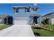 Charming two-story home with landscaped yard, blue exterior, and attached two-car garage at 2459 Taloncrest Ct, Eagle Lake, FL 33839