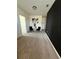 Bright hallway with neutral carpet and black accent wall is staged with modern artwork and contemporary decor at 2459 Taloncrest Ct, Eagle Lake, FL 33839