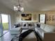 Bright living room with a large sectional sofa, stylish decor, and sliding glass door to backyard at 2459 Taloncrest Ct, Eagle Lake, FL 33839