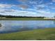 Beautiful serene water view with a large pond reflecting a blue sky with fluffy white clouds at 2459 Taloncrest Ct, Eagle Lake, FL 33839