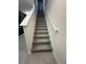 Carpeted staircase with white railing leads to the upper level, offering a smooth transition between floors at 2459 Taloncrest Ct, Eagle Lake, FL 33839