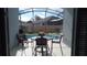 Outdoor patio with table and chairs overlooking a pool and spa enclosed in a screened enclosure at 2645 Oneida Loop, Kissimmee, FL 34747