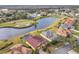 Aerial view of a house community with golf course and lake at 304 Sorrento Road, Poinciana, FL 34759