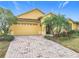 Landscaped front yard with brick driveway at 304 Sorrento Road, Poinciana, FL 34759