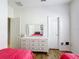 Well-lit bedroom with hardwood floors, white dresser, and two twin beds at 512 Heartwell Dr, Poinciana, FL 34759