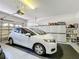 Garage with car, storage cabinets and flooring at 512 Heartwell Dr, Poinciana, FL 34759